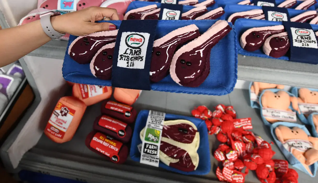 Pengunjung memegang barang di instalasi seni berjudul 'Sparrow Mart Supermarket' di hotel The Standard, Los Angeles, 10 Agustus 2018. Setiap item dibuat tanpa menggunakan mesin, termasuk label harga yang ditulis dengan spidol. (MARK RALSTON/AFP)