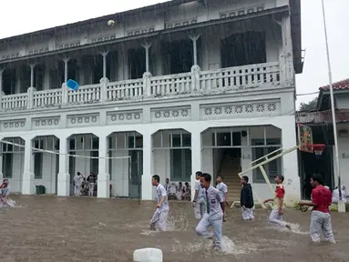  Siswa SMK 1 Budi Utomo beraktivitas di tengah genangan hujan yang merendam sekolah mereka, Jakarta, Senin (9/2/2015). (Antara Foto/Fanny Octavianus)
