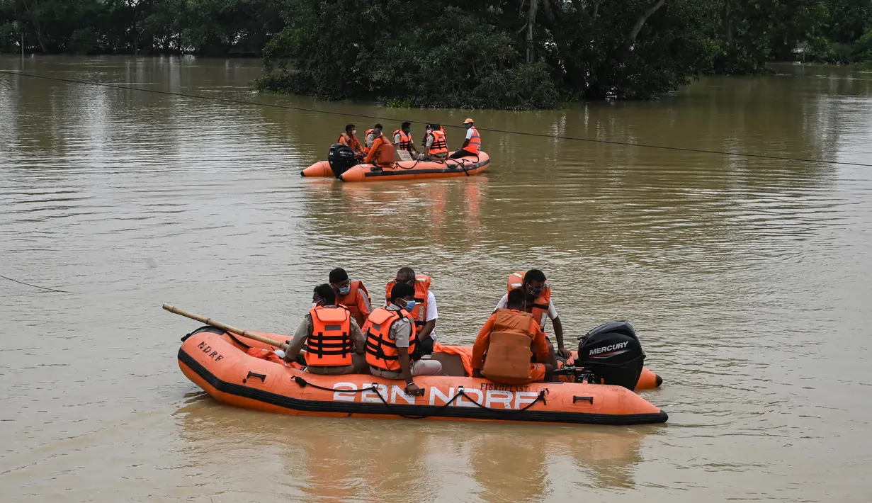 Anggota Pasukan Tanggap Bencana Nasional (NDRF) berpatroli mencari korban banjir di Ghatal, distrik Paschim Medinipur, sekitar 100 km dari Kolkata (2/8/2021). (AFP/Dibyangshu Sarkar)
