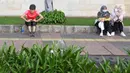 Warga beristirahat di kawasan bundaran HI, Jakarta, Minggu (12/6/2022). Car Free Day di kawasan Sudirman-Thamrin dimanfaatkan warga untuk berolah raga dan ber foto-foto. (Liputan6.com/Herman Zakharia)