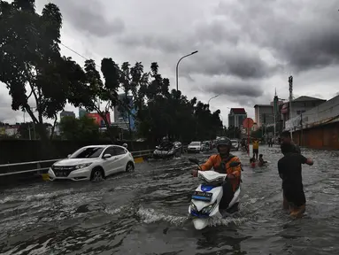 Pengendara motor berusaha menerobos genangan air di ruas Jalan Satrio, Grogol, Jakarta Barat, Rabu (29/1/2025). (merdeka.com/Arie Basuki)