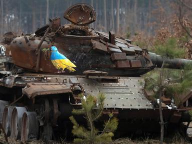 Sebuah tank Rusia yang hancur bergambarkan burung merpati dengan cabang zaitun karya seniman jalanan terkenal TvBoy di tengah serangan Rusia terhadap Ukraina di Desa Dmytrivka, luar Kyiv, Ukraina, 30 Januari 2023. Karya seni yang dibuat untuk menghormati para korban perang Rusia-Ukraina tersebut mengandung pesan kelahiran kembali dan harapan serta berharap agar konflik segera berakhir. (AP Photo/Efrem Lukatsky)