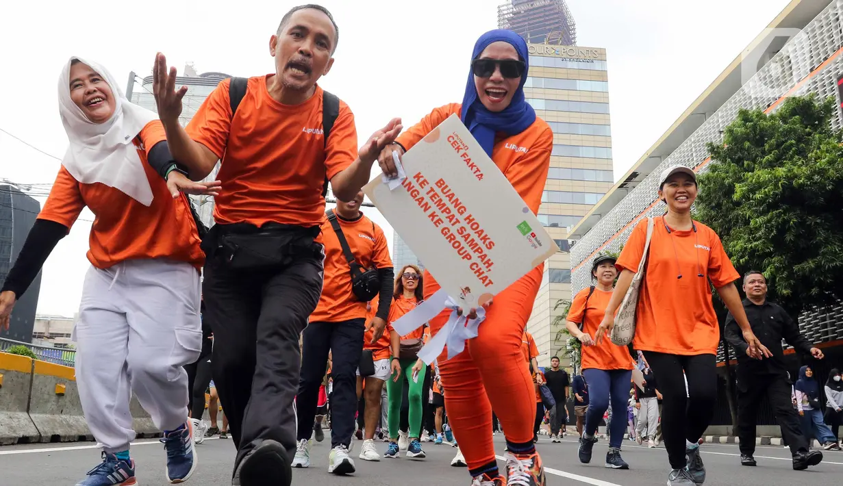 Para pegiat Cek Fakta Liputan6.com saat berkegiatan Fun Walk di Hari Bebas Kendaraan Bermotor atau Car Free Day (CFD) di Jalan MH Thamrin, Jakarta, Minggu (23/2/2025). (Liputan6.com/Herman Zakharia)