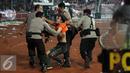 Petugas kepolisian mengamankan seorang suporter usai terlibat bentrok saat laga Persija melawan Sriwijaya FC pada lanjutan Torabika Soccer Championship presented by IM3 Ooredoo diStadion GBK Jakarta, Jumat (24/6). (Liputan6.com/Helmi Fithriansyah)