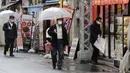 Warga memakai masker untuk melindungi dari penyebaran virus corona berjalan di jalan yang dipenuhi bar dan restoran di Tokyo (8/3/2021). Pemerintah Jepang memperpanjang keadaan darurat di wilayah Tokyo hingga 21 Maret karena sistem medis masih disaring oleh pasien COVID-19. (AP Photo/Koji Sasahara)