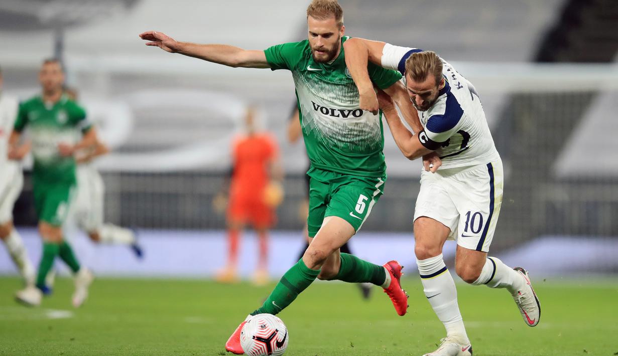 Penyerang Tottenham, Harry Kane, berebut bola dengan bek Maccabi Haifa, Bogdan Planic, pada laga play-off Liga Europa 2020/2021 di Tottenham Hotspur Stadium, Jumat (2/10/2020) dini hari WIB. Tottenham menang 7-2 atas Maccabi Haifa. (AFP/Adam Davy/pool)