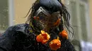 Seorang peserta terkena jeruk saat perang-perangan selama karnaval di kota Ivrea, Italia, Minggu (7/2). Peserta yang dibagi menjadi dua tim ini saling melempar jeruk menggunakan kostum dan aksesoris lengkap. (REUTERS/Stefano Rellandini)