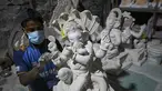Perajin mengerjakan patung dewa Hindu berkepala gajah Lord Ganesha di sebuah lokakarya menjelang festival Ganesh Chaturthi di Mumbai (12/8/2021). Festival Ganesh Chaturthi adalah perayaan kelahiran Ganesha, dewa kebijaksanaan, kemakmuran, dan keberuntungan Hindu. (AFP/Punit Paranjpe)