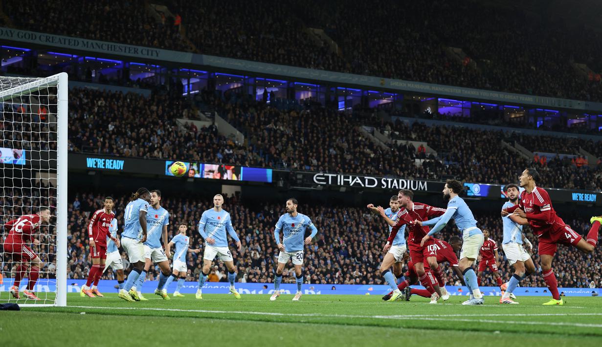 Pemain Liverpool, Virgil van Dijk, mencetak gol melalui tandukan kepalanya ke gawang Manchester City pada lanjutan Liga Inggris Etihad Stadium, Minggu (09/1, 1/2025) malam WIB. (AFP/Darren Staples)