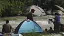 Imigran dari Amerika Tengah dan Venezuela berkemah di tepi Sungai Huixtla, negara bagian Chiapas, Meksiko, Rabu (8/6/2022). Rombongan itu meninggalkan Tapachula pada hari Senin, lelah menunggu status mereka di wilayah dengan sedikit pekerjaan dan jauh dari tujuan akhir mereka mencapai Amerika Serikat. (AP Photo/Marco Ugarte)
