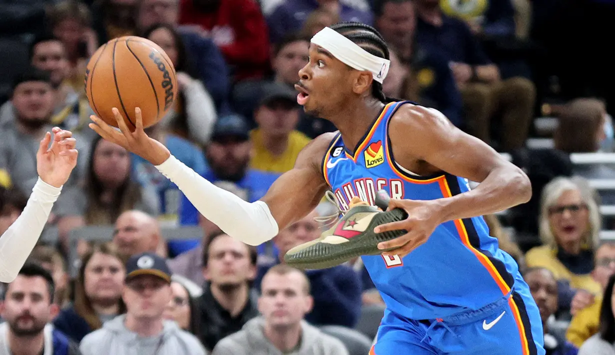 Pebasket Oklahoma City Thunder, Shai Gilgeous-Alexander berusaha meraih bola sambil memegang septunua saat laga melawan Indiana Pacers di Gainbridge Fieldhouse, Indianapolis, Indiana, 31 Maret 2023. Shai Gilgeous-Alexander merupakan salah satu pebasket andalan Timnas Kanada. Sejauh ini, ia pernah mendapatkan beberapa penghargaan yaitu, NBA All Star 2023, NBA All-Rookie Second Team 2019, Second-team All-SEC 2018, SEC All-Freshman Team 2018, dan SEC tournament MVP 2018. (AFP/Getty Images/Andy Lyons)