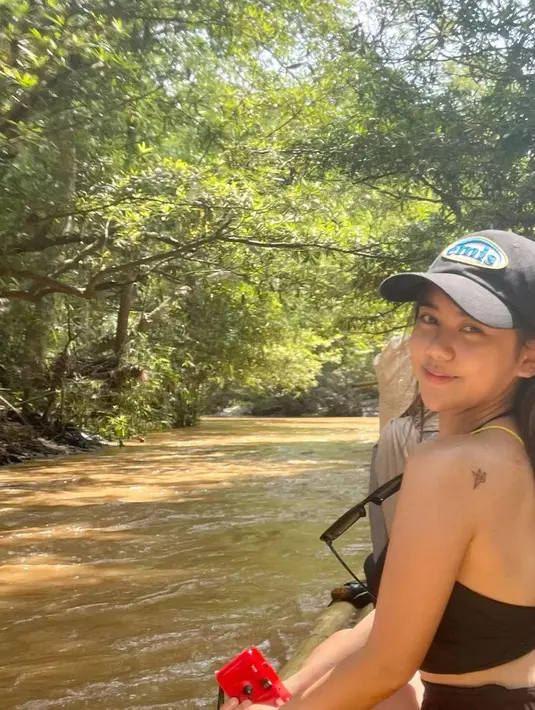<p>Menyusuri sungai, Ziva mengenakan backless cropped top hitam yang memperlihatkan gambar di kecil di punggungnya. [Foto: @zivamagnolya]</p>