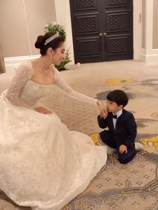 Dalam salah satu foto, Angel Karamoy menunjukkan sisi keibuannya saat berinteraksi dengan sang anak. Anak Angel Karamoy dari pernikahannya terdahulu menjadi bukti kasih sayangnya sebagai ibu. Momen haru terlihat ketika seorang bocah bersetelan tuxedo mencium tangannya dengan penuh hormat.  (Liputan6.com/IG/@realangelkaramoy)