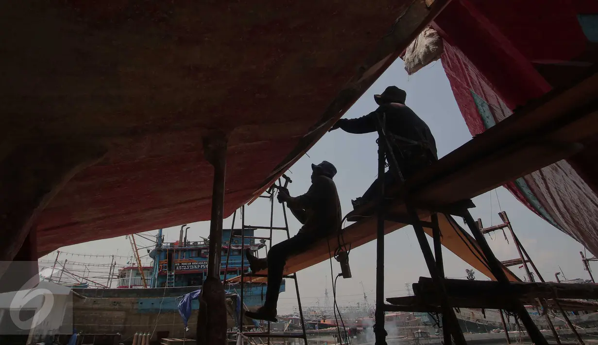 Pekerja memperbaiki bagian lambung kapal ikan di Unit Docking Kapal Perikanan kawasan Muara Angke, Jakarta, Senin (9/11/2015). Perawatan tersebut dilakukan setiap 6 bulan untuk menjamin keamanan dan keselamatan para nelayan (Liputan6.com/Angga Yuniar)