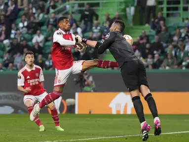 Penyerang Arsenal, Reiss Nelson menantang bola dengan kiper  Sporting CP, Antonio Adan dalam laga leg pertama babak 16 besar Liga Europa 2022-2023 di Estadio Jose Alvalade, Jumat (10/3/2023) dini hari WIB.  Arsenal dipaksa puas dengan hasil imbang 2-2 dalam lawatan ke markas Sporting Lisbon.  (AP Photo/Armando Franca)