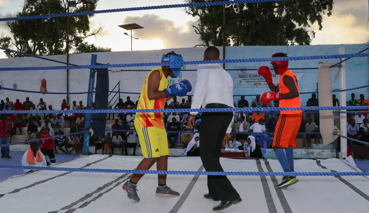 Petinju Somalia, Kashmir Abdirahim Abdalla (kiri) bertanding di atas ring Stadion Wish, ibu kota Mogadishu pada 15 November 2018. Setelah lebih dari tiga dekade berlalu Somalia akhirnya kembali menggelar kejuaraan tinju. (Abdirazak Hussein FARAH / AFP)