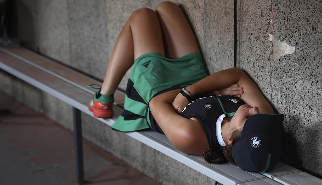 Ball girl beristirahat sejenak usai bekerja pada ajang Roland Garros 2017, Prancis Terbuka, Paris (29/5/2017). (AFP/Lionel Bonaventure)