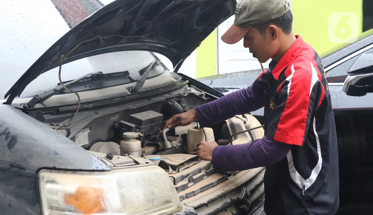 Mekanik mengecek mesin mobil yang terendam banjir di sebuah bengkel di Jakarta, Rabu (8/1/2020). Kerusakan pada mobil yang terendam banjir meliputi interior, kabel dan kelistrikan, serta bagian mesin. (Liputan6.com/Angga Yuniar)
