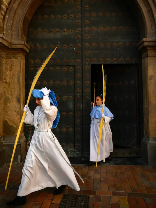 Para peniten muda mempersiapkan diri sebelum ambil bagian dalam prosesi Minggu Palma di Zaragoza, Spanyol, Minggu (25/3). (Foto AP/Alvaro Barrientos)