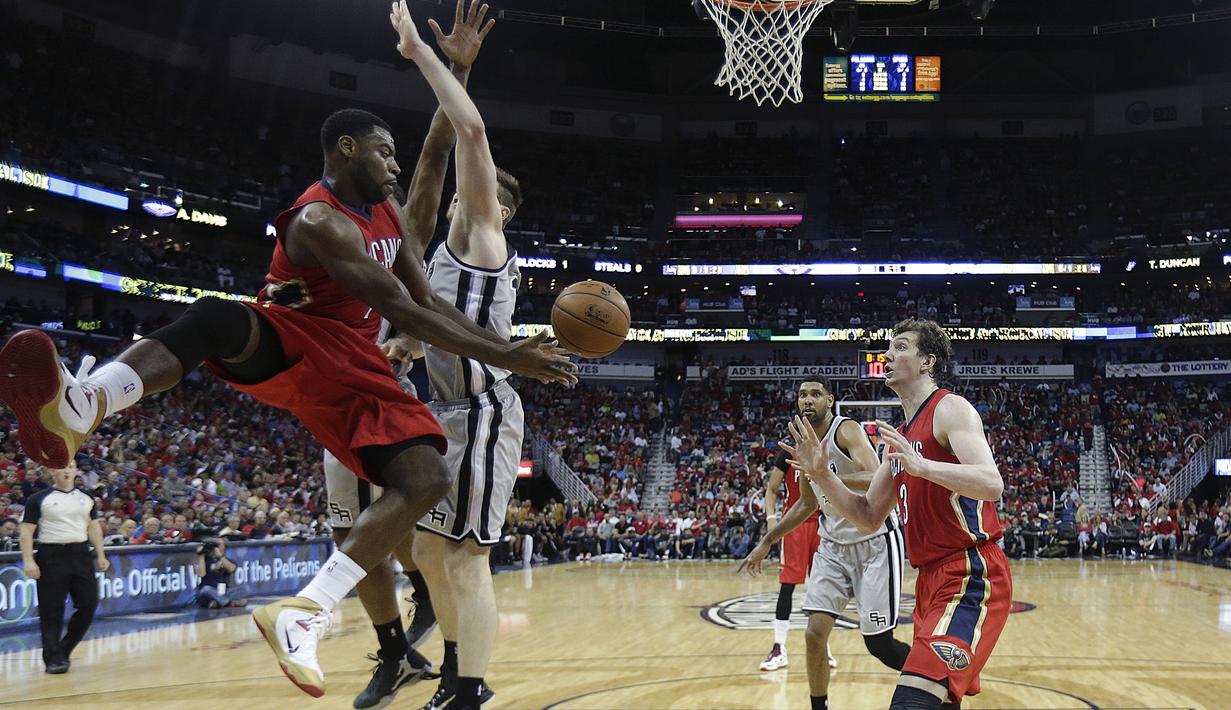  Guard Pelicans Tyreke Evans coba memberikan assist kepada rekan setimnya Omer Asik walau coba diadang oleh center San Antonio Spurs Aron Baynes.(AP Photo/Gerald Herbert)