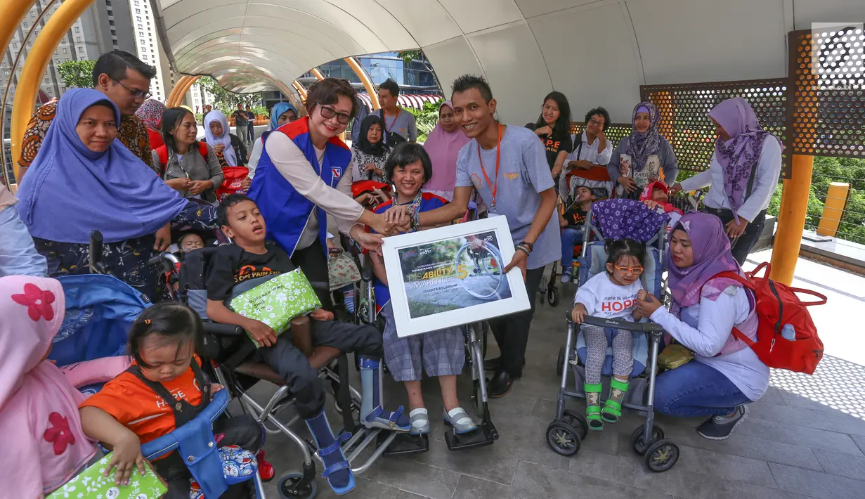 Perwakilan Bidang Sosial Yayasan Agung Podomoro Land (YAPL) Christie Damayanti (tengah), Sekretariat YAPL Uke Tantya (kiri) memberikan donasi kepada perwakilan Rumah Harapan Indonesia Ichsan Nur Haryono di Eco Sky Walk Neo Soho, Jakarta Barat, Kamis (2/5/2019). (Liputan6.com/Fery Pradolo)