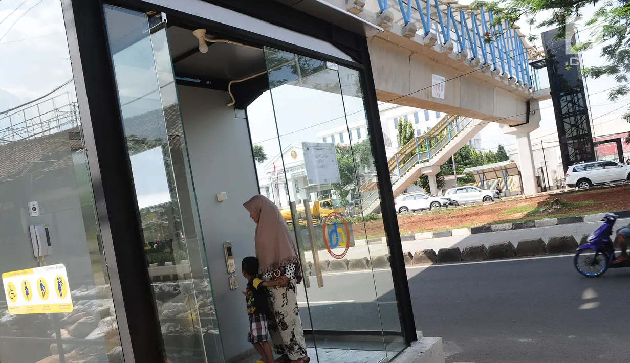 Warga menaiki lift jembatan penyeberangan orang (JPO) Sumarno, Jakarta, Kamis (10/1). Lift JPO Sumarno sudah bisa digunakan. (Liputan6.com/Herman Zakharia)