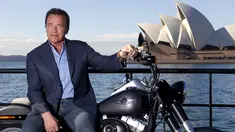 Mantan Gubernur California, Arnold Schwarzenegger berpose dengan duduk di atas motor Harley Davidson saat mempromosikan film terbarunya, `Terminator Genisys` di depan Sydney Opera House, Australia, Kamis (4/6/2015). (REUTERS/David Gray)