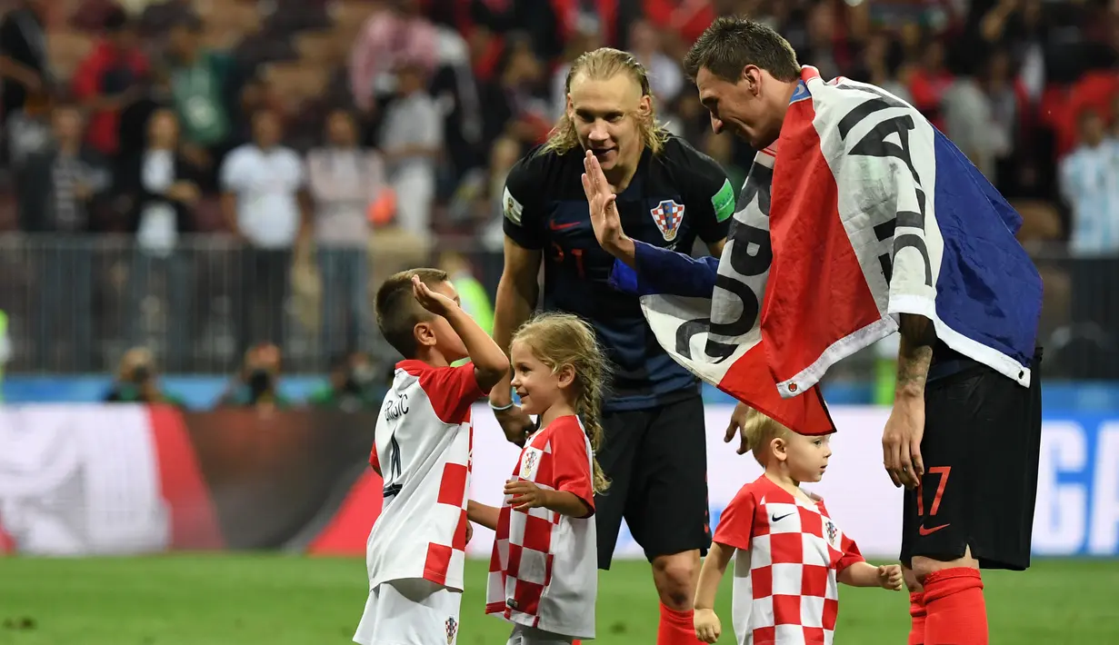 Pemain depan Kroasia, Mario Mandzukic (kanan) menyapa anak Ivan Perisic, Leonardo (kiri) dan Manuela (dua kiri) usai laga semifinal Piala Dunia 2018 antara Kroasia dan Inggris di Stadion Luzhniki, Moskow, Rabu, Rabu (11/7). (AFP PHOTO/YURI CORTEZ)