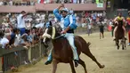 Joki dari contrada Onda, Carlo Sanna memacu kudanya Porto Alabe saat mengikuti balapan kuda Italia historis Palio di Siena, Italia (16/8). Perlombaan kuda yang digelar di Siena ini paling meriah di Italia. (AFP Photo/Filippo Monteforte)