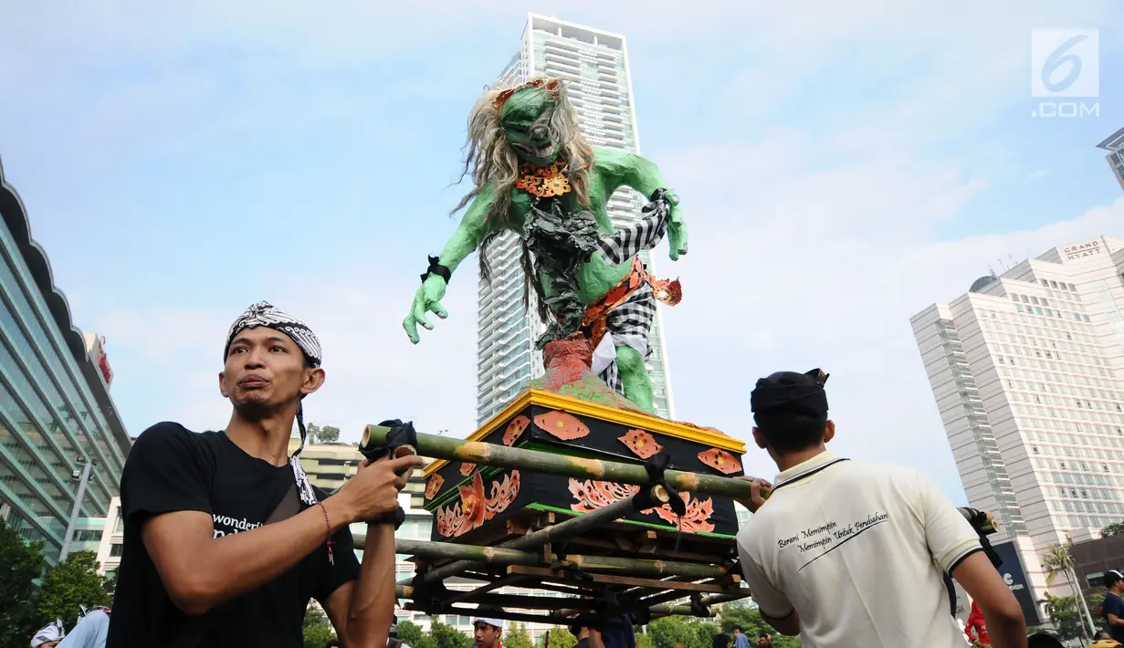 Aktivis Perhimpunan Pemuda Hindu Indonesia menampilkan tarian ogoh-ogoh saat aksi penggalangan dana untuk pengungsi Gunung Agung saat Hari Bebas Kendaraan di Kawasan Bundaran HI Jakarta, Minggu (1/10). (Liputan6.com/Helmi Fithriansyah)