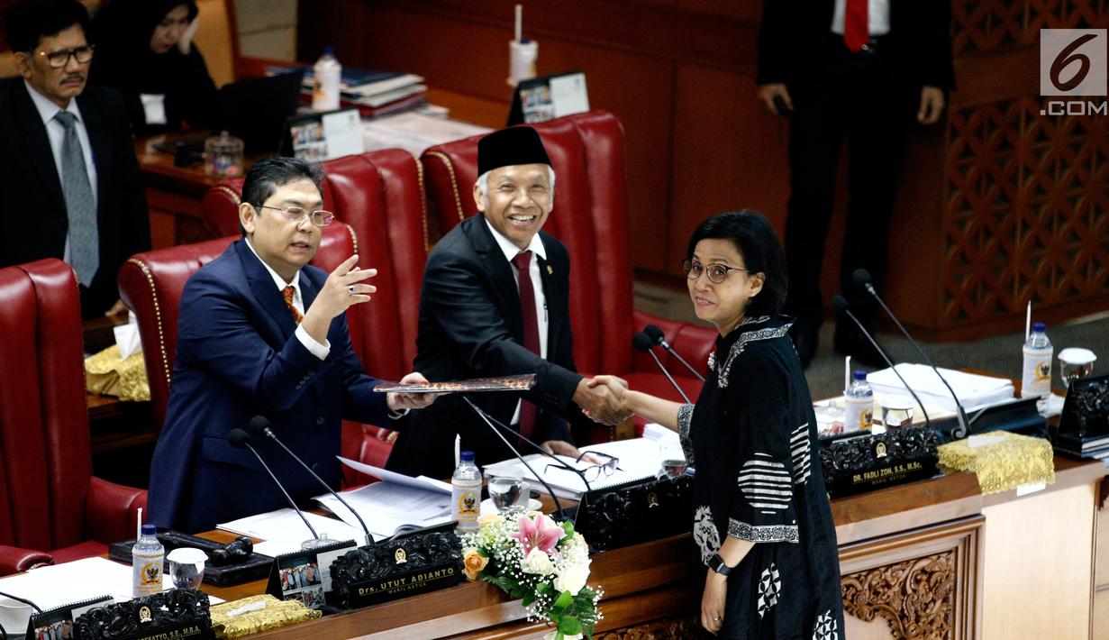 Menkeu Sri Mulyani  bersalaman dengan Wakil Ketua DPR Agus Hermanto saat Rapat Paripurna di Jakarta, Kamis (4/7/2019). Rapat membahas berbagai agenda salah satunya Penyampaian RUU tentang Penanggungjawaban atas Pelaksanaan RAPBN (P2APBN) TA 2018 Pemerintah. (Liputan6.com/Johan Tallo)