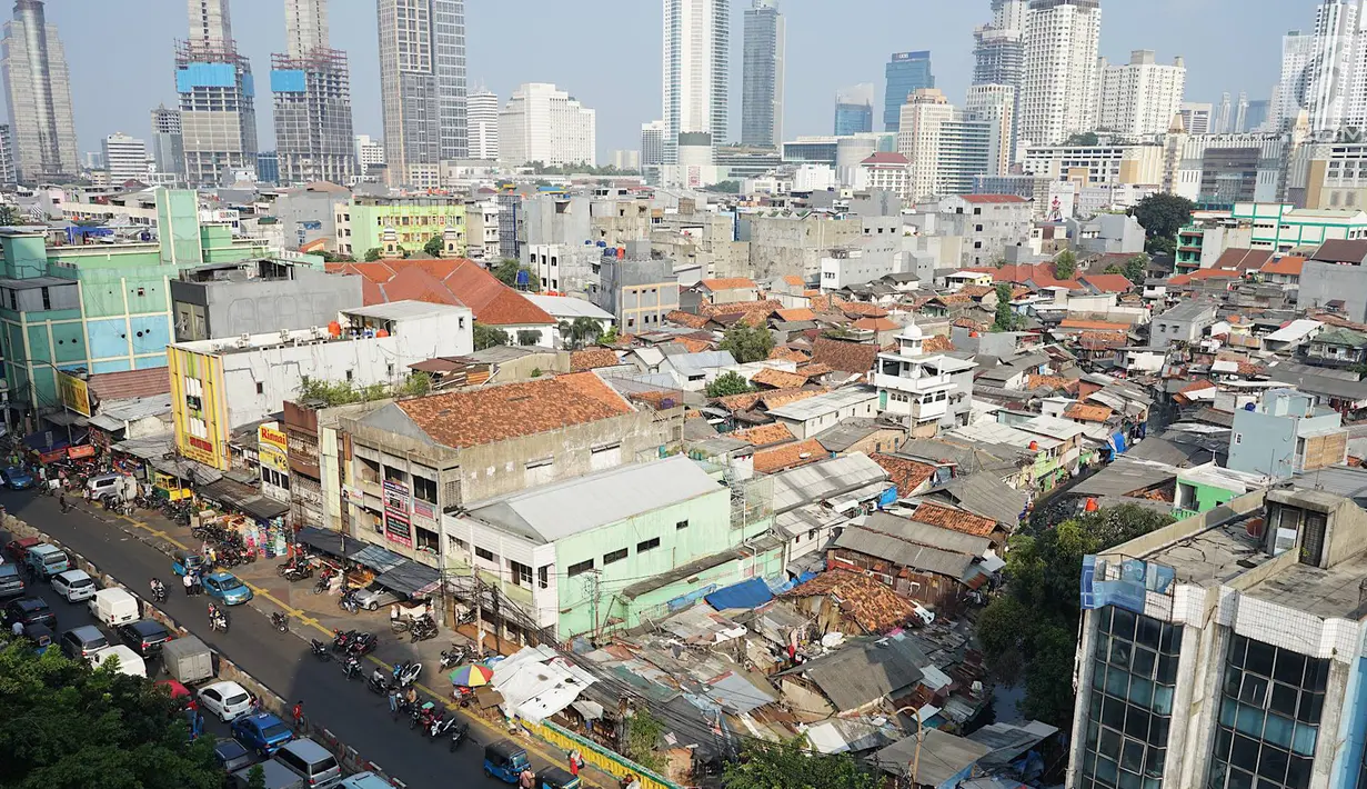 Lansekap pemukiman penduduk berlatar gedung bertingkat terlihat dari Tanah Abang, Jakarta, Selasa (21/5). Laporan Oxford Economics berjudul Global Cities 2018 menyebut Jakarta akan jadi kota dengan jumlah penduduk terbesar di dunia pada 2035, yakni 38 juta jiwa. (Liputan6.com/Immanuel Antonius)