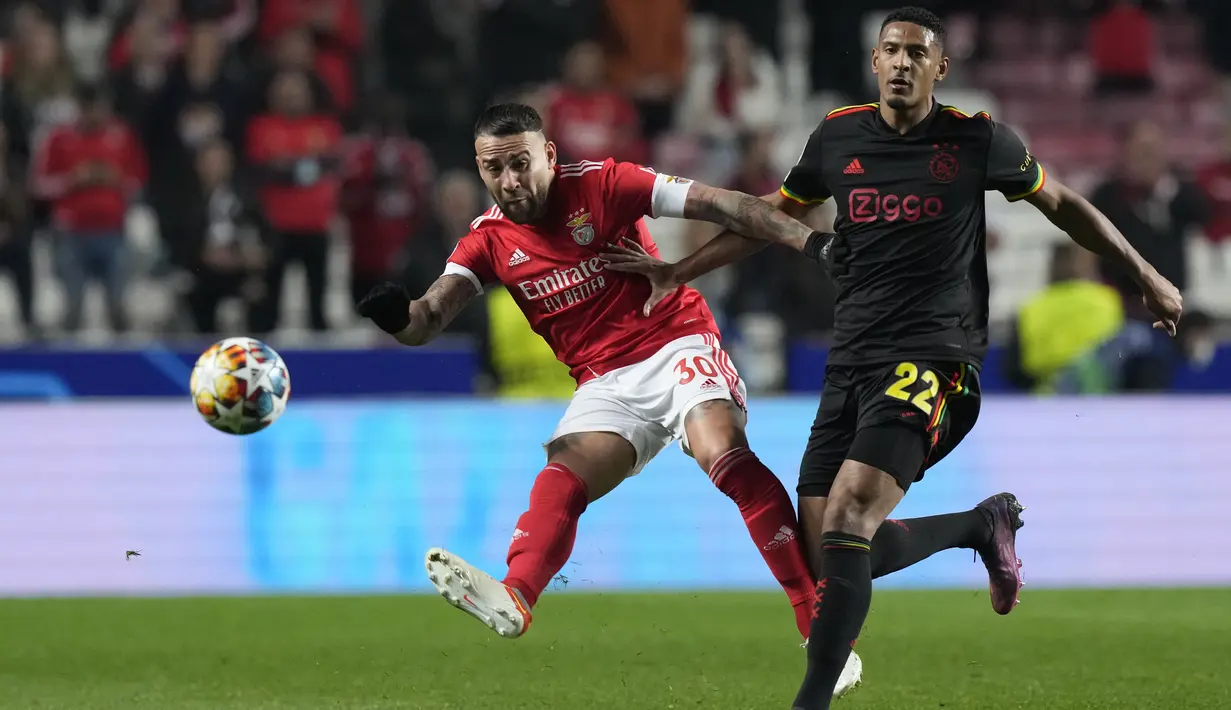 Bek Benfica, Nicolas Otamendi (kiri) berusaha mengumpan bola dari kawalan penyerang Ajax, Sebastien Haller pada pertandingan leg pertama babak 16 Liga Champions di Stadion Da Luz, Lisbon, Kamis (24/2/2022). Benfica bermain imbang atas Ajax 1-1.  (AP Photo/Armando Franca)