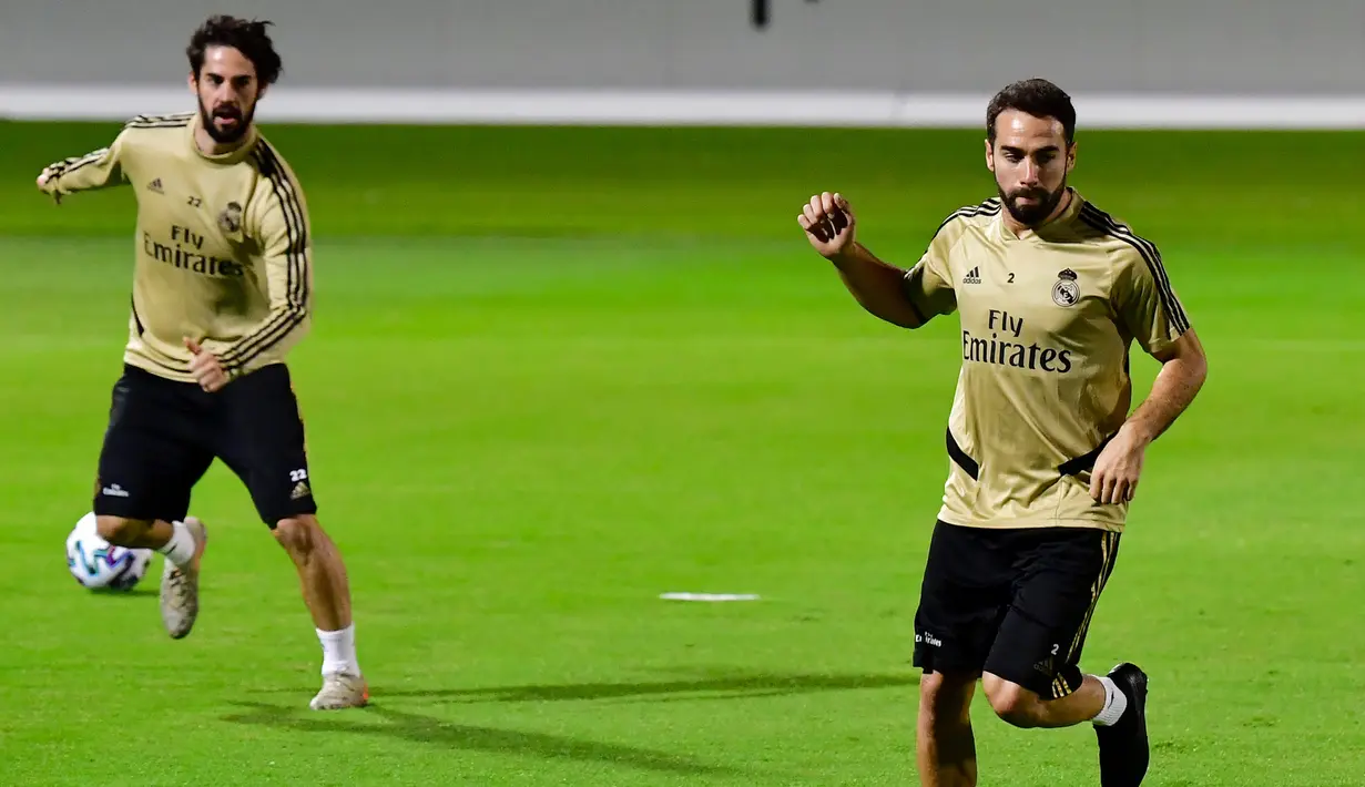 Bek Real Madrid, Dani Carvajal (kanan) dan gelandang Isco saat mengikuti sesi latihan tim di King Abdullah Sport City di kota pelabuhan Arab Saudi, Jeddah (7/1/2020). Real Madrid akan bertanding melawan Valencia pada semifinal Piala Super Spanyol pada Kamis (9/1/2020) dini hari WIB. (AFP/Giuseppe Ca