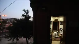 Umat Muslim berbuka puasa di Masjid Jama yang sepi, yang biasanya dipadati ribuan umat selama bulan suci Ramadan, karena penguncian nasional untuk mengendalikan penyebaran virus corona Covid-19, di New Delhi, India (25/4/2020). (AP Photo/Manish Swarup)