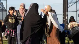 Wanita muslim saling berpelukan saat mereka bersiap melaksanakan salat Idul Adha di Taman Bensonhurst di wilayah Brooklyn di New York (1/9). Umat Muslim di seluruh dunia merayakan Hari RayaIdul Adha. (AP Photo / Mark Lennihan)