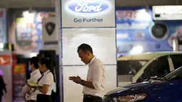 Seorang Salesman saat menunggu pelanggan di pameran mobil di Jakarta Fair, Jakarta, 30 Juni 2015. Pabrikan asal Amerika Tersebut itu tak kuat lagi berkompetisi di Indonesia dan para karyawan akan dirumahkan. (REUTERS / Nyimas Laula)