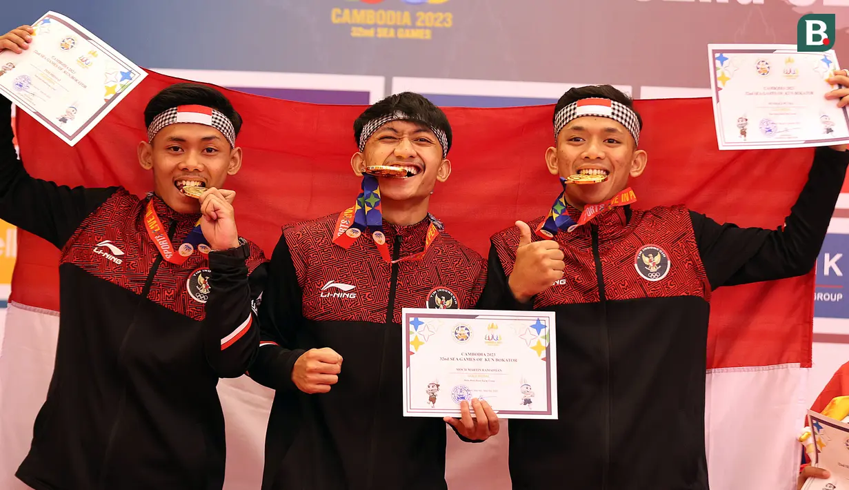 <p>Atlet Kun Bokator putra Indonesia, Muhammad Martin Ramadhan, Tedi Hidayat, Sendiri Putra menunjukkan medali emas dari nomor Men's Bare Hand Form Group Kun Bokator SEA Games 2023 di Chrouy Changvar Convention Center, Phnom Penh, Kamboja, Senin (8/5/2023). (Bola.com/Abdul Aziz)</p>
