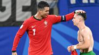 Penyerang Portugal #07 Cristiano Ronaldo mengucapkan selamat kepada #26 Francisco Conceicao setelah ia mencetak gol kedua timnya ke gawang Republik Ceko pada laga grup F Euro 2024 di Red Bull Arena, Leipzig, Rabu (19/6/2024) dini hari WIB. (Christophe SIMON / AFP)