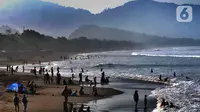 Wisatawan beraktifitas di pinggir pantai di kawasan Pantai Karang Naya, Pelabuhan Ratu, Sukabumi, Selasa (1/6/2021). Walaupun liburan lebaran telah usai sejumlah pantai di kawasan Pelabuhan Ratu masih dipadati pengunjung yang berasal dari Kota Jakarta dan Jawa Barat.(merdeka.com/Arie Basuki)