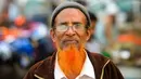 Dalam gambar yang diambil pada 24 Desember 2018, seorang pria bernama Eklas Ahmed berpose dengan janggut oranye di Dhaka. Belakangan ini, pria-pria Muslim Bangladesh keranjingan berpenampilan dengan janggut warna-warna terang seperti merah hingga oranye. (MUNIR UZ ZAMAN / AFP)