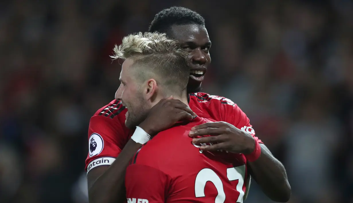 Pemain Manchester United, Luke Shaw (depan) dipeluk Paul Pogba (belakang) usai mencetak gol ke gawang Leicester City dalam ajang Liga Inggris di Old Trafford, Manchester, Inggris, Jumat (10/8). MU menang 2-1 atas Leicester City. (AP Photo/Jon Super)