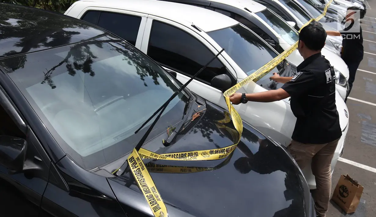 Petugas memberi garis polisi pada barang bukti kasus sindikat pencurian kendaraan bermotor di Polda Metro Jaya, Jakarta, Kamis (14/3). Polisi membekuk delapan tersangka dalam kasus ini. (Liputan6.com/Immanuel Antonius)