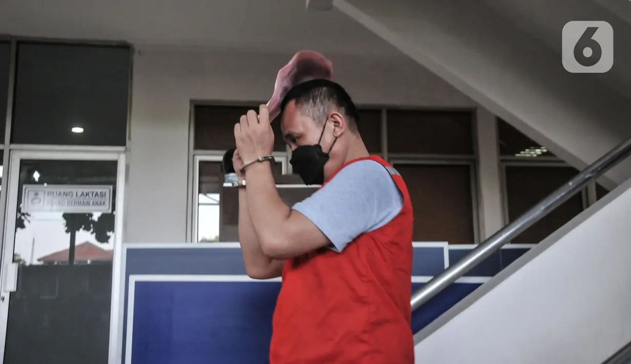 Tersangka lainnya mengenakan rompi merah Kejaksaan saat menuju mobil tahanan usai pelimpahan tahap II kasus narkoba di Kejaksaan Negeri Jakarta Barat, Rabu (11/1/2023). Penyidik Ditresnarkoba Polda Metro Jaya resmi melimpahkan berkas perkara kasus narkoba mantan Kapolda Sumatera Barat Irjen Pol Teddy Minahasa dan sejumlah tersangka ke Kejari Jakarta Barat. (merdeka.com/Iqbal S Nugroho)