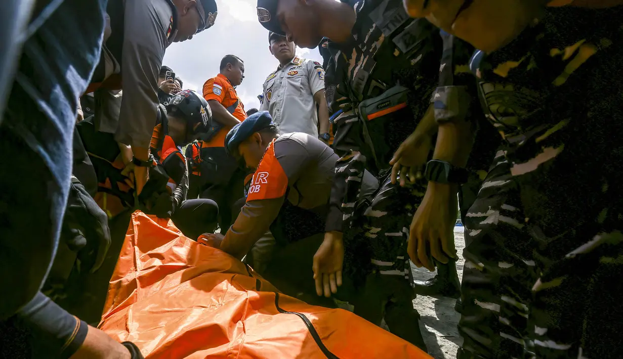 Petugas SAR  gabungan mengevakuasi korban meninggal setelah  turun dari kapal pencarian dan penyelamatan di Pelabuhan Lembar, Lombok Barat, Rabu, 12 Agustus 2026. (AFP)