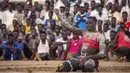 Pegulat pemenang mengangkat tinjunya ke udara dalam kompetisi gulat tradisional Nuba antara tim dari daerah Haj Youssef dan Omdurman di Ibu Kota Khartoum, Sudan, 30 Juli 2021. (Abdulmonam EASSA/AFP)