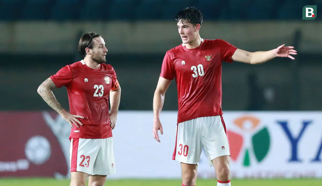 Pemain Timnas Indonesia, Elkan Baggot (kanan) berbincang dengan Mark Klok saat melawan Bangladesh pada laga uji coba FIFA Matchday antara Timnas Indonesia menghadapi Bangladesh di Stadion Si Jalak Harupat, Bandung, Rabu (1/6/2022) malam WIB. (Bola.com/M. Iqbal Ichsan)