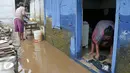 Warga mebersihkan sisa-sisa endapan lumpur di rumahnya, Cawang, Jakarta, Senin (7/11). Sebelumnya, ratusan rumah warga di RW 02 Cawang, Kramat Jati, Jakarta Timur tergenang akibat banjir kiriman dari kawasan Bogor. (Liputan6.com/Yoppy Renato)
