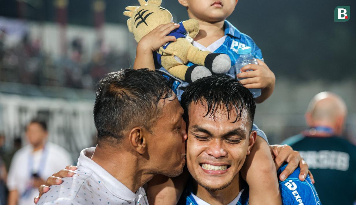Ciuman bangga Sugiantoro kepada sang anak, bek Persib Bandung, Rachmat Irianto dalam perayaan gelar juara Championship Series BRI Liga 1 2023/2024 setelah mengalahkan Madura United 3-1 pada laga final leg kedua di Stadion Gelora Bangkalan, Madura, Jumat (31/5/2024). (Bola.com/Bagaskara Lazuardi)