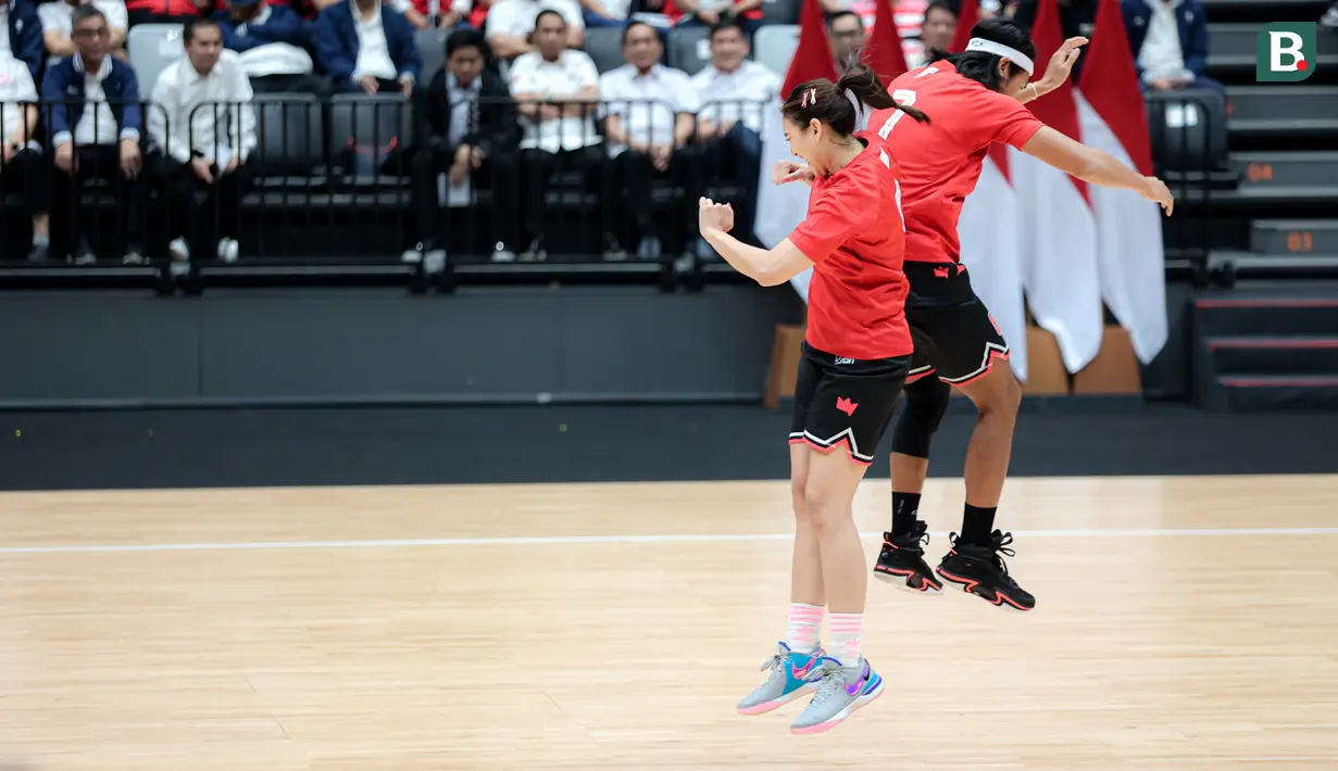 Pevoli Timnas putri Indonesia, Yolla Yuliana (kiri) melakukan tos badan dengan Sean Gelael saat laga eksibisi sebelum peresmian Indonesia Arena di Senayan, Jakarta, Senin (07/08/2023). (Bola.com/Bagaskara Lazuardi)